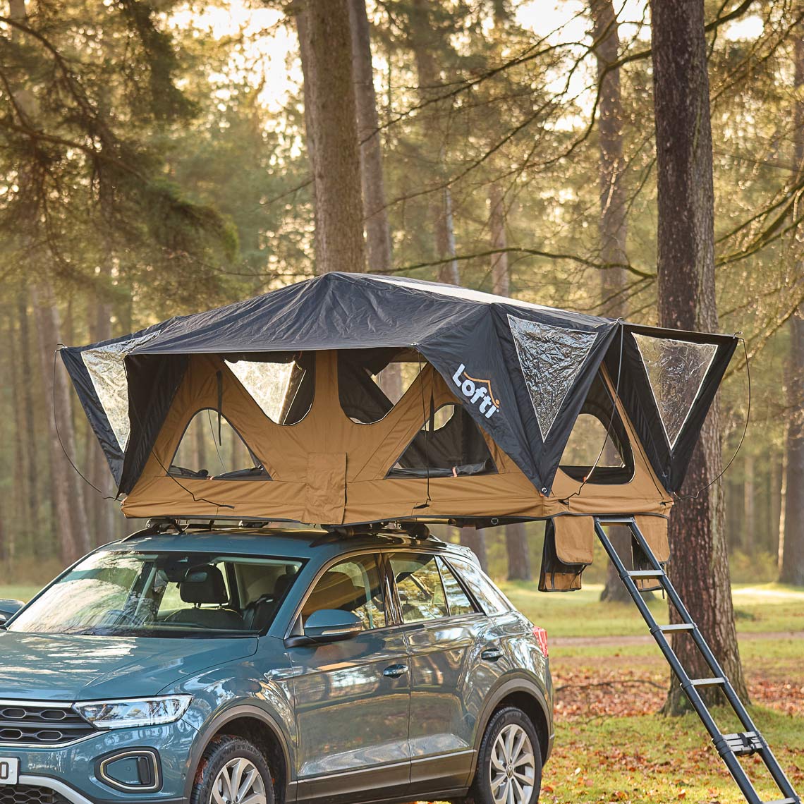 Lofti Bertha rooftop tent open on a blue VW T-Roc in a pine forest